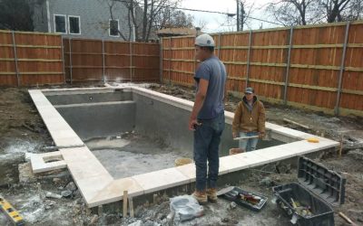 Two pool technicians working on a pool