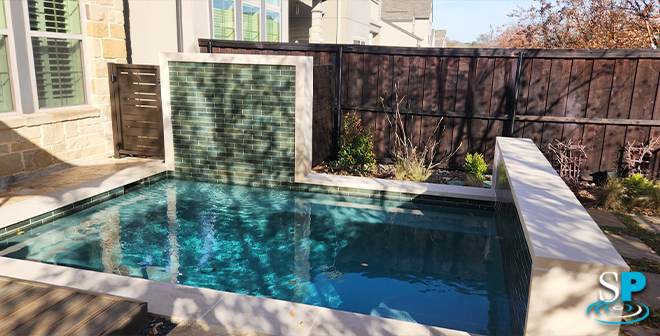 small modern pool with a fountain wall