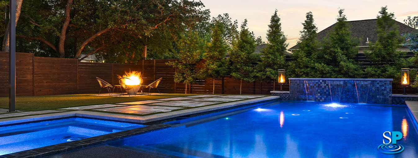 pool with a lit up fire pit next to it