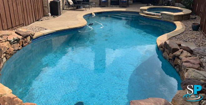 a before picture of a lagoon style pool