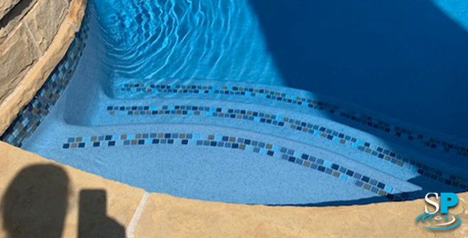 an after photo of steps in a pool with new plaster and tile