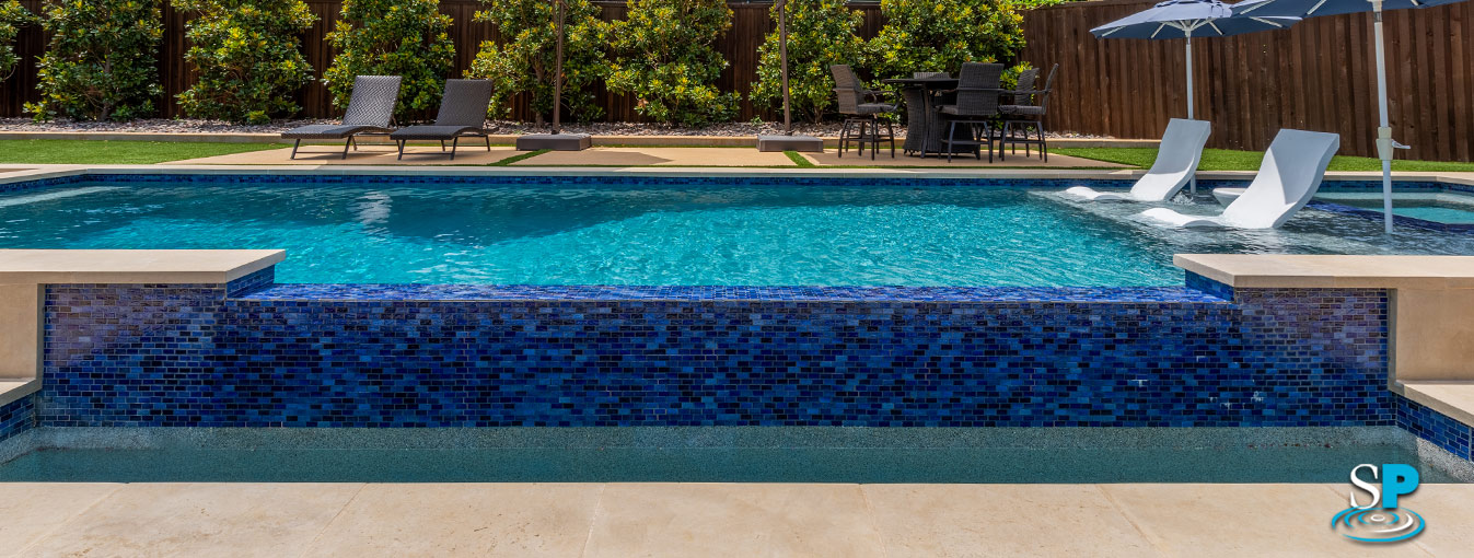 a infinity edge pool made of bright and dark blue tiles