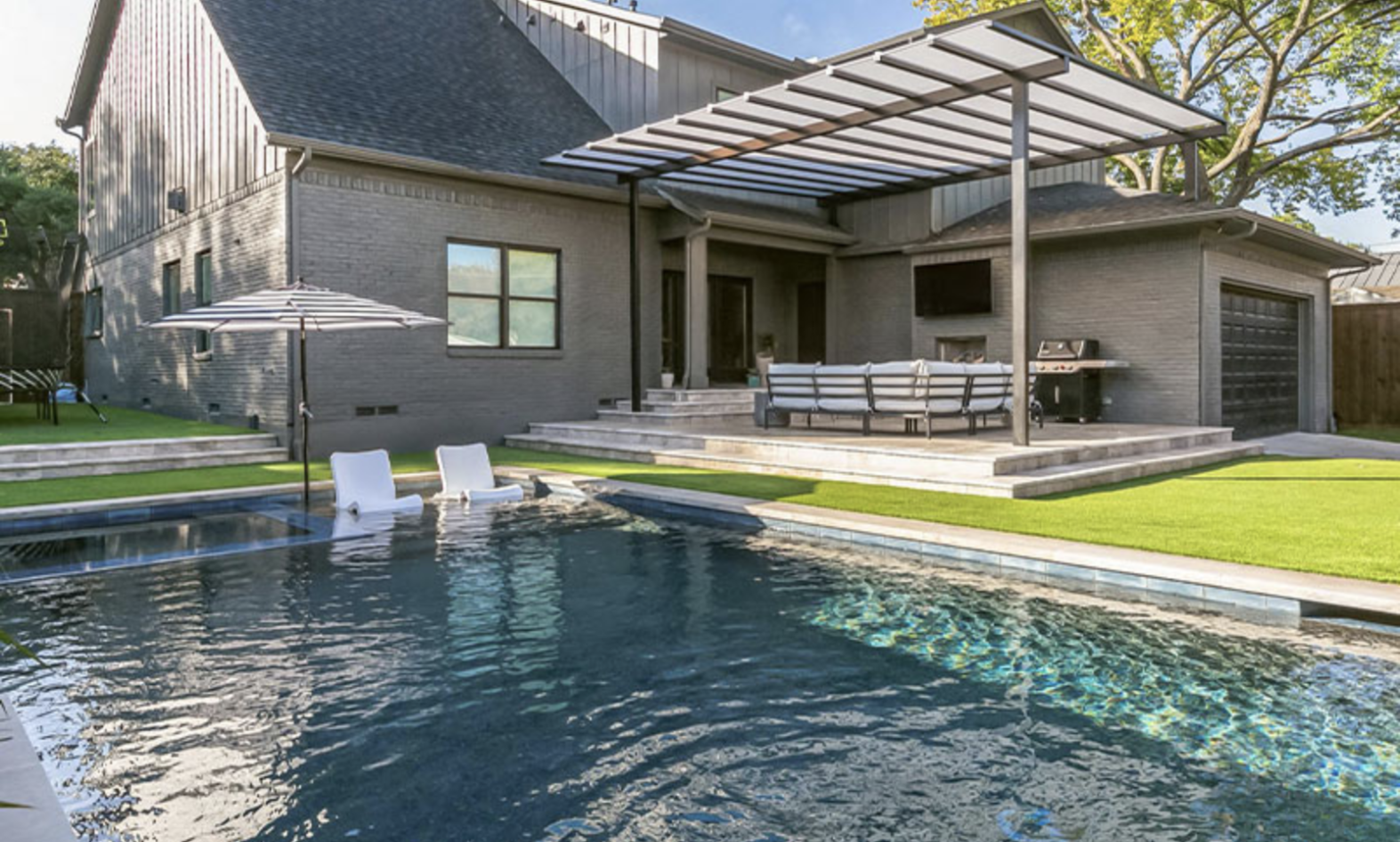 Swimming Pool in the backyard with a Pergola and sitting arrangement