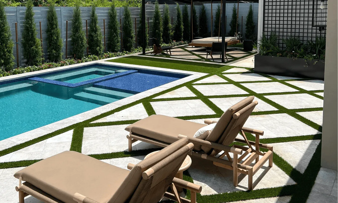 Luxury custom pool and spa in Texas, featuring a diamond-patterned travertine and turf deck, modern black pergola with hanging bed, and a white contemporary farmhouse exterior.