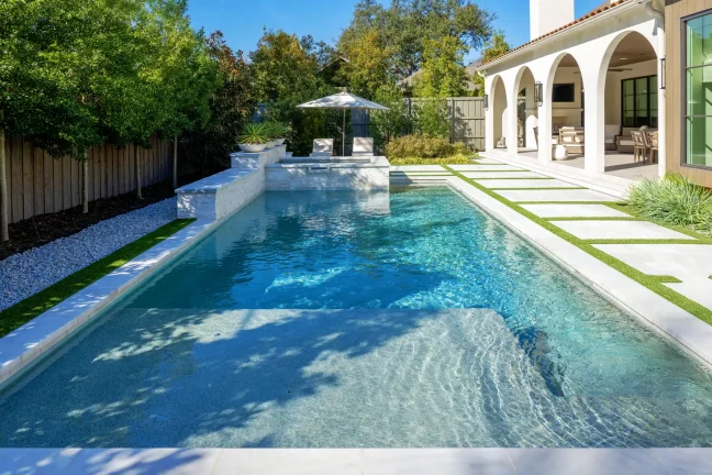 Initial pool layout and staking in Dallas, TX, using pink paint and wooden stakes to mark the footprint of a custom geometric pool and outdoor living space.